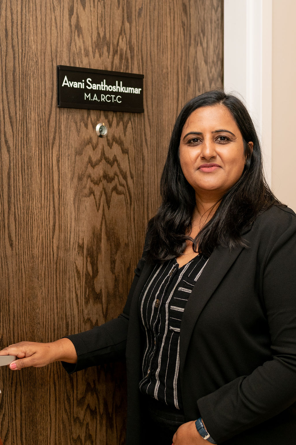 Avani at her office door at Wholetherapy